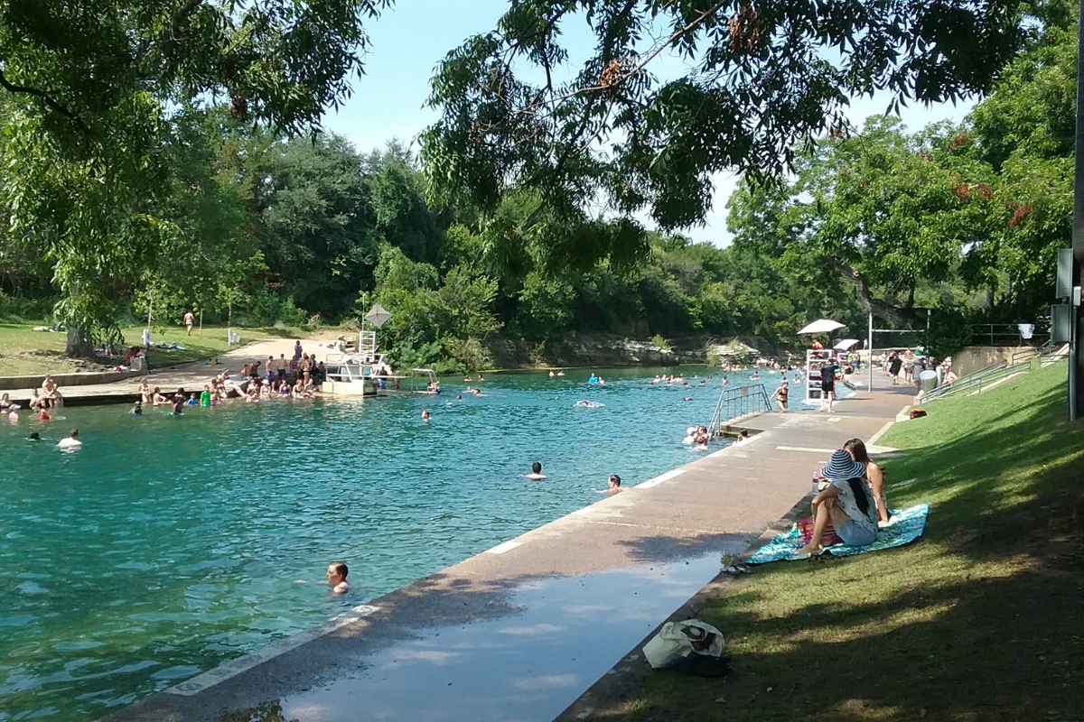 Swimmers in the clear green water of Barton Springs Pool in Austin, a few miles from the Heywood Hotel
